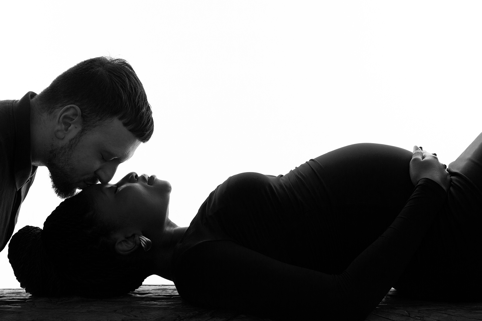 Father to be kissing mother to be on the forehead