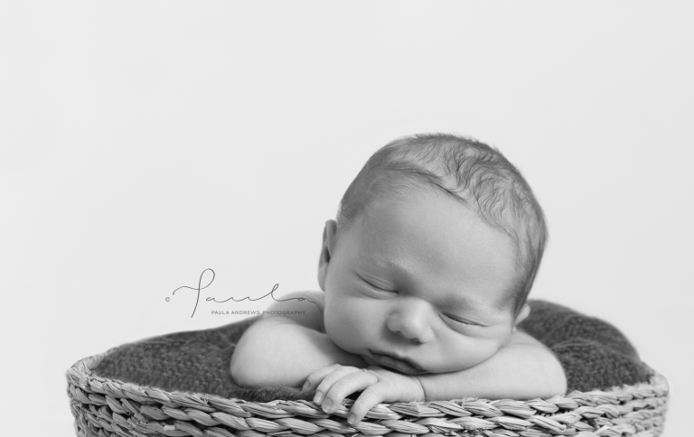 Newborn with chin on arms