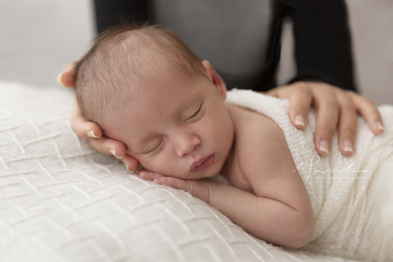 Mother gently putting her newborn daughter down to sleep