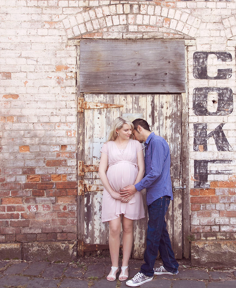 Husband kissing pregnant wife on shoulder