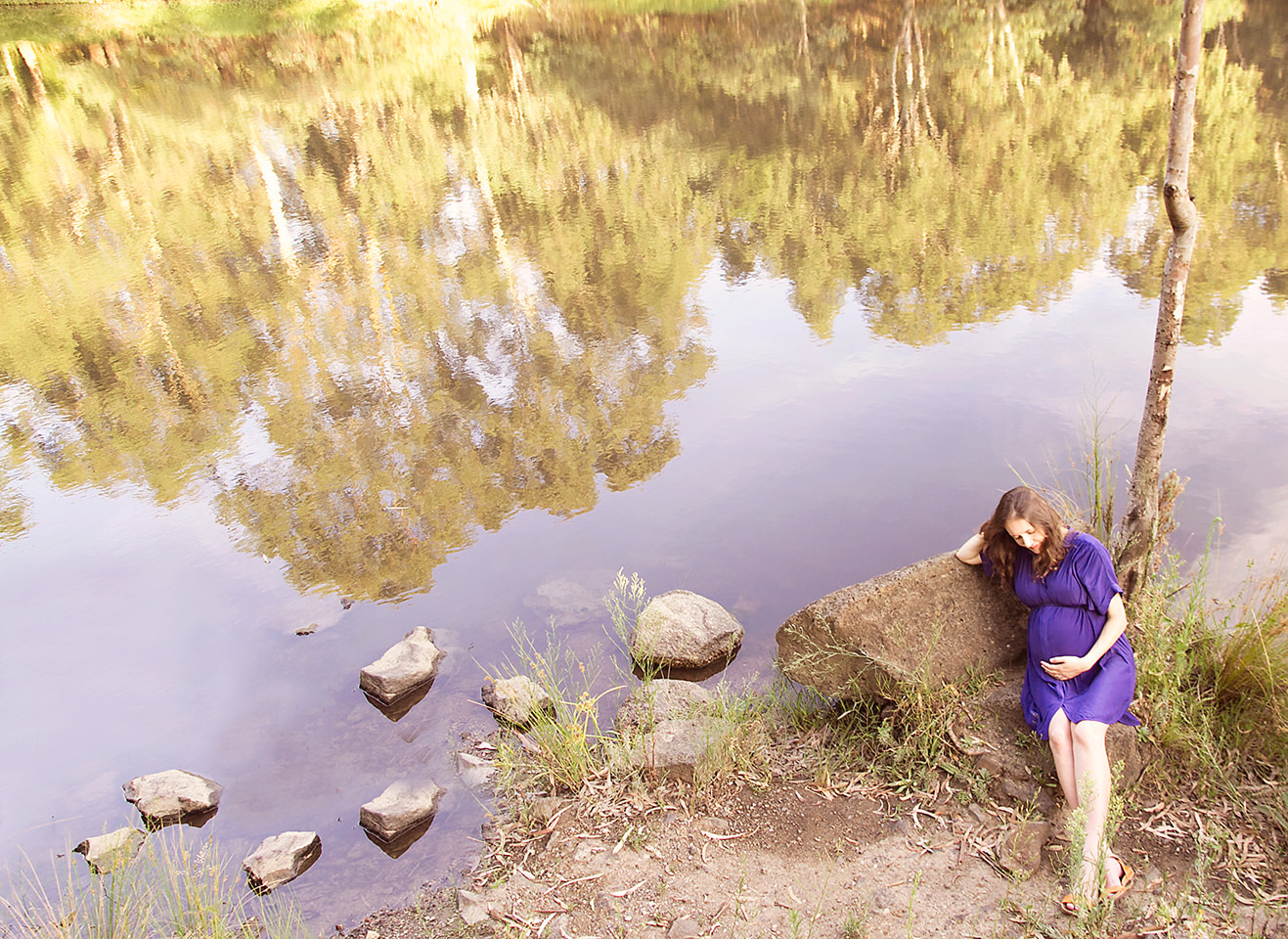 Pregnant lady sitting riverside