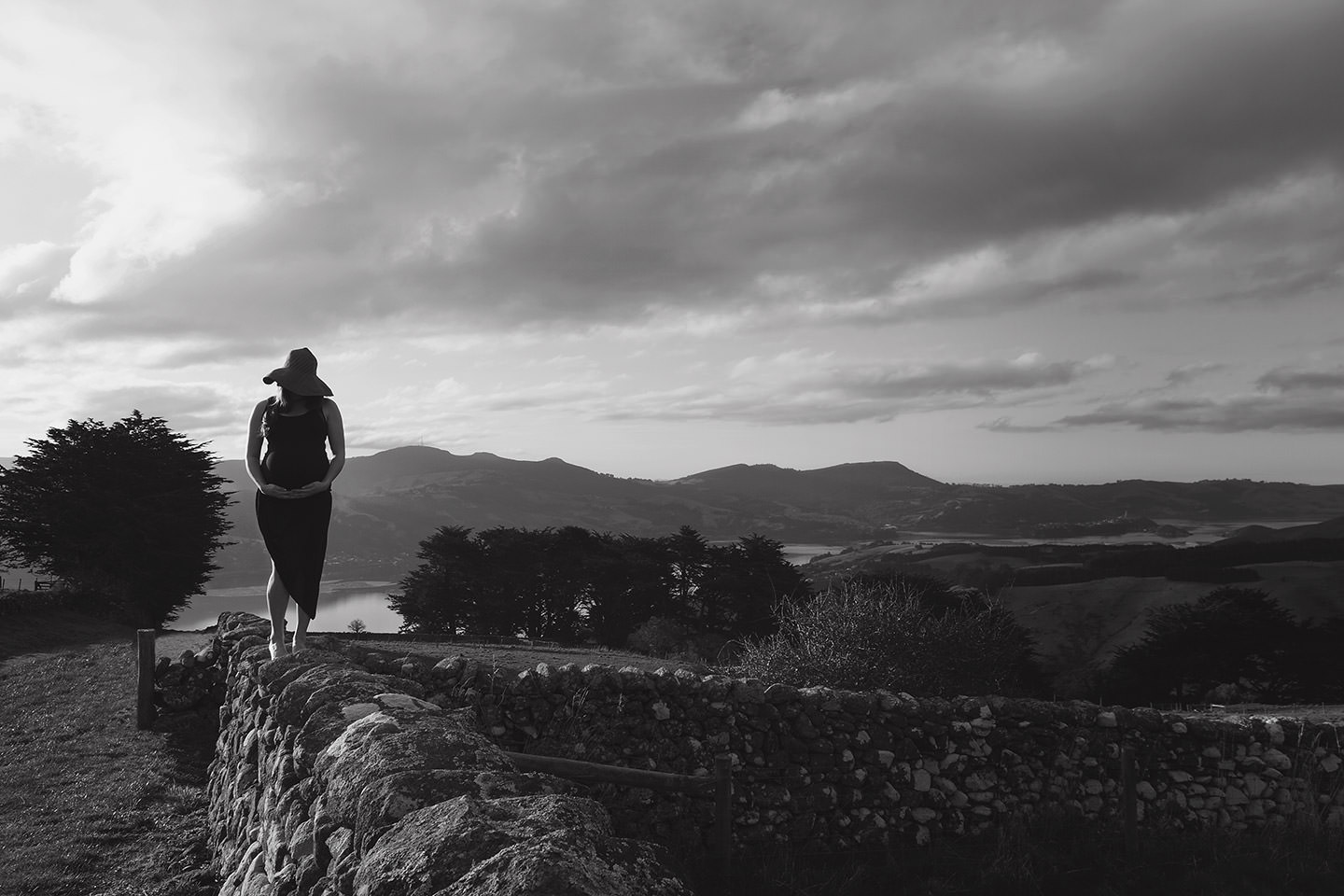 Pregnant lady on stone wall on Otago Peninsula
