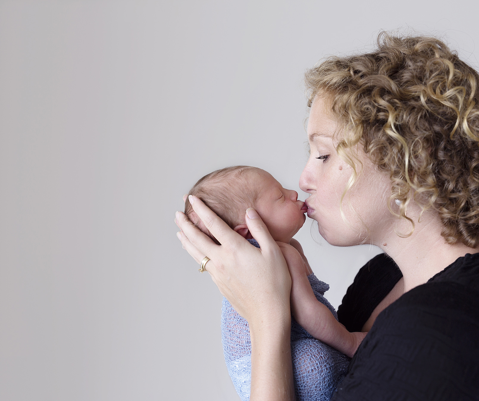 Mum kissing baby boy on lips