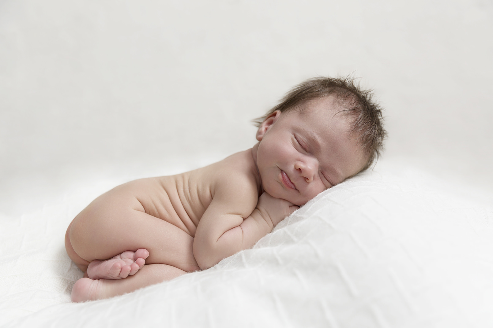 Cheeky newborn with lots of baby rolls