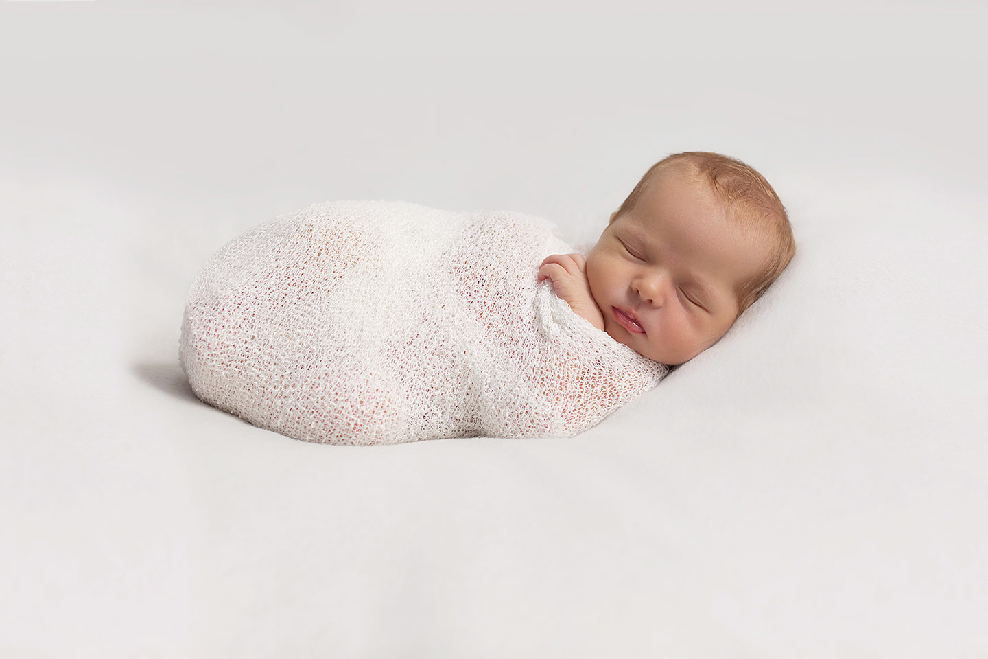 Baby wrapped in white cocoon