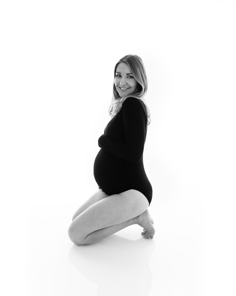 pregnant women in black leotard kneeling in side on pose