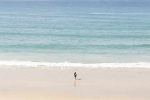 Surfer entering water at Noosa Heads in the Sunshine Coast